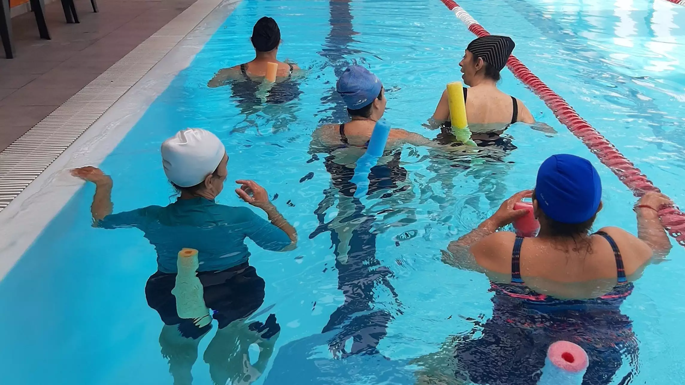 Personas en una terapia de fisioterapiadentro de una piscina